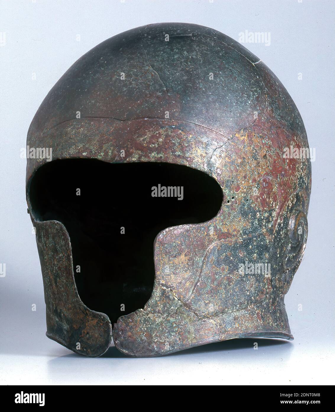 Casque avec indication d'oreille, bronze, chassé, riveté, bronze, Total : hauteur : 29 cm ; largeur : 17 cm ; profondeur : 19.5 cm, vêtements de protection, armes (guerre/militaire), objets et accessoires rituels, armure (guerre/militaire), archaïque précoce, antiquité grecque, le casque est constitué de deux parties, qui sont rivetées ensemble par une couture longitudinale chevauchante au centre du crâne. Protection du front, de la joue et du menton ne laissez qu'une petite partie du visage libre. Le contour de la barbe et des cheveux principaux est représenté par une légère élévation de relief plane. Banque D'Images