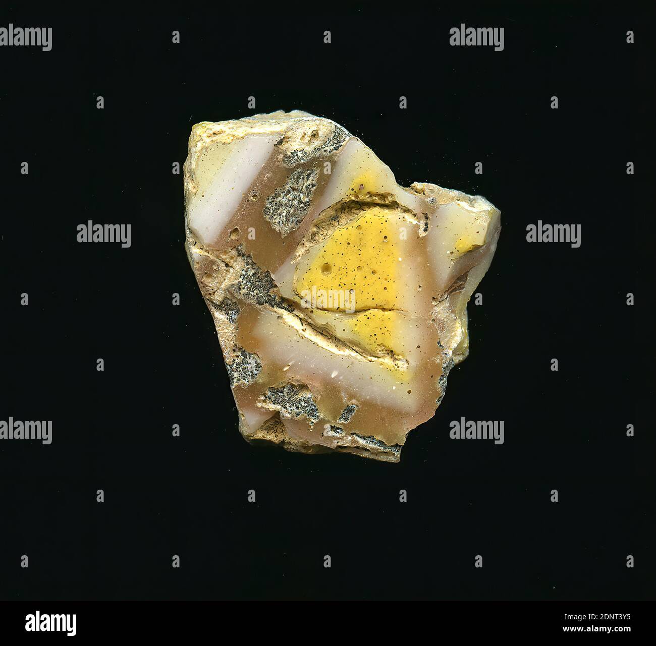 Fragment d'un vaisseau, verre, pressé, coupé, Total: Hauteur: 2.20 cm; largeur: 2.00 cm, conteneur, stockage, travail de cuisine, début de la période impériale, UNE légère courbure du fragment de verre permet l'affectation à un vaisseau, éventuellement un bol. Le fragment présente un motif géométrique sur un fond marron clair. Autour des triangles jaunes, une bande de verre blanche peut être vue, suivie de triangles similaires. Des traces de corrosion ou de fritté sont visibles à la surface. Pour la production, des verres de différentes couleurs ont été formés en tubes et en tiges. Ils ont été pressés ensemble et chauffés, ce qui a donné une longue tige. Banque D'Images