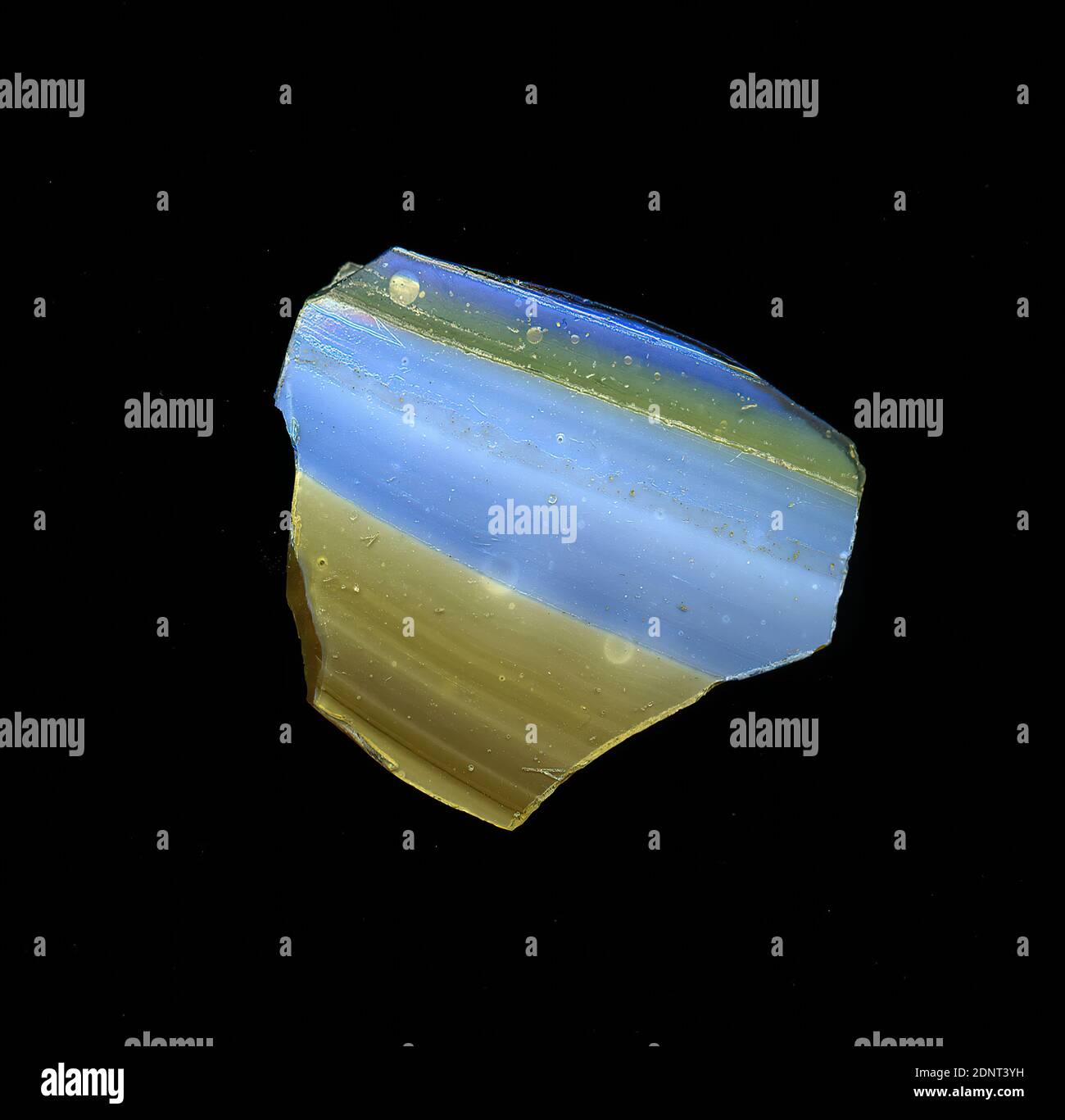 Fragment d'un vaisseau, verre, pressé, coupé, Total: Hauteur: 3.10 cm; largeur: 2.60 cm, conteneur, stockage, travail de cuisine, début de la période impériale, UNE légère courbure du fragment de verre permet l'affectation à un vaisseau, éventuellement un bol. Des bandes parallèles bleues et brunes alternées sont visibles sur la vitre, d'un côté deux plus minces, de l'autre côté deux plus épais. Le dos est marron. Pour la production, différentes verres de couleur ont été pressés ensemble et chauffés. En raison du processus de fabrication complexe et de sa fragilité, le verre a été considéré comme l'un des articles de luxe de l'antiquité Banque D'Images