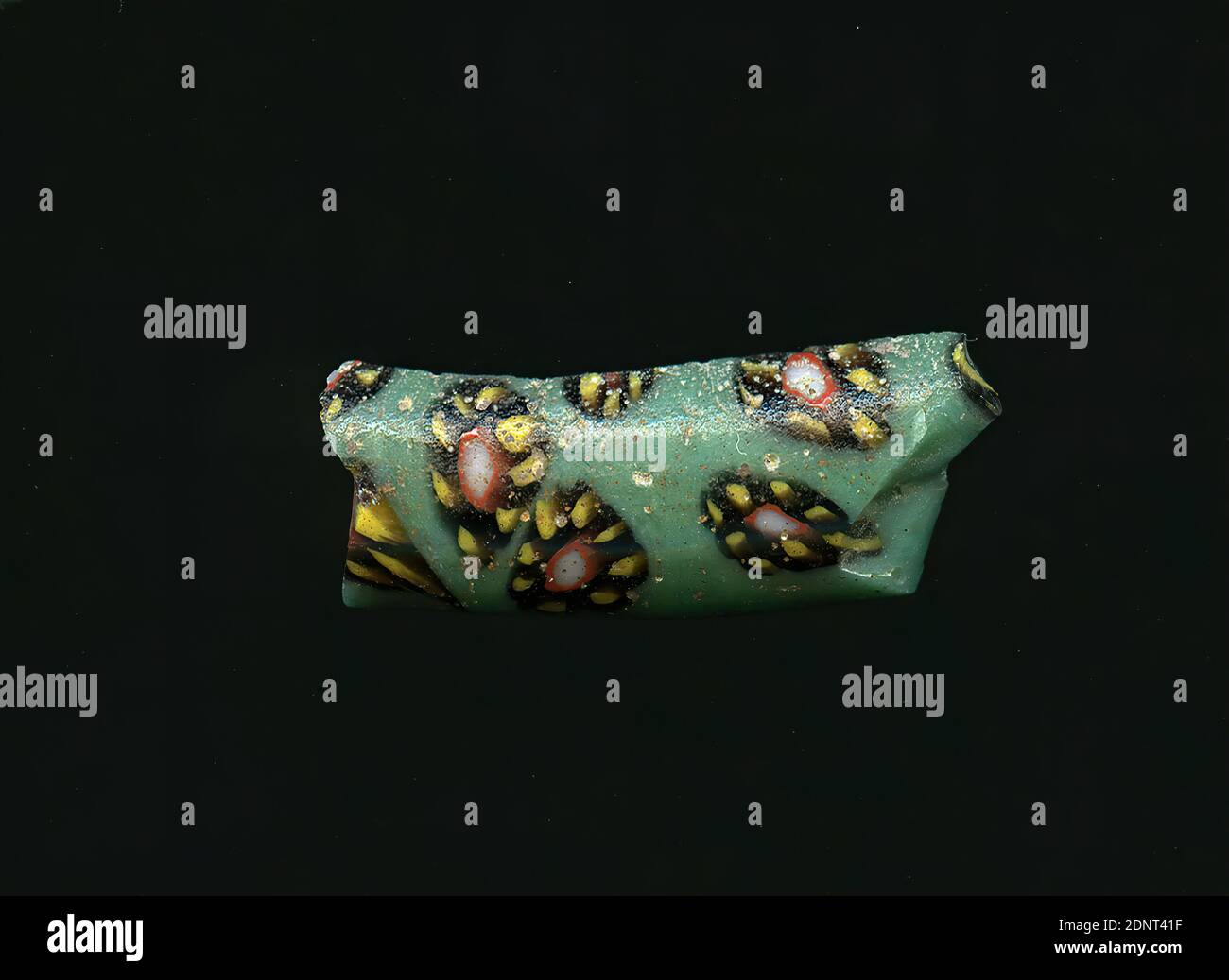 Fragment d'un vaisseau, verre, technique millefiori, Total: Hauteur: 1.10 cm; largeur: 2.70 cm, contenant, stockage, cuisine, ustensiles de bar et de boisson, ornements floraux, début de la période impériale, UNE légère courbure du fragment de verre permet l'affectation à un vaisseau, éventuellement le bord d'un bol. Le verre turquoise montre plusieurs fleurs dans la technique de millefiori. Ils se composent d'un point blanc avec un contour rouge, autour duquel les points jaunes avec un contour noir sont placés comme des pétales. Pour la production, des verres de différentes couleurs ont été formés en tubes et en tiges. Banque D'Images