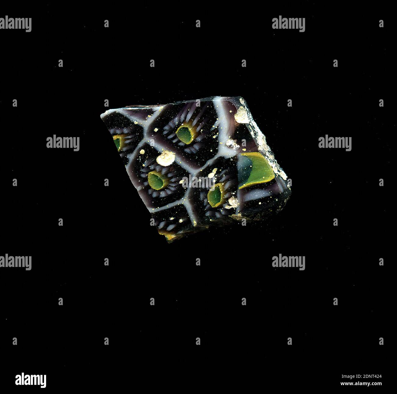 Fragment d'un vaisseau, verre, technique millefiori, Total: Hauteur: 1.70 cm; largeur: 2.10 cm, conteneur, stockage, travail de cuisine, ornements floraux, période impériale précoce, UNE légère courbure du fragment de verre permet l'affectation à un vaisseau, éventuellement un bol. Le merde violet est parsemé d'une grille de lignes blanches rappelant les nids de miel. Au centre, il y a un point bleu avec un contour jaune autour duquel les points blancs circulaires sont regroupés sous forme de pétales. Pour la production, des verres de différentes couleurs ont été formés en tubes et en tiges. Banque D'Images