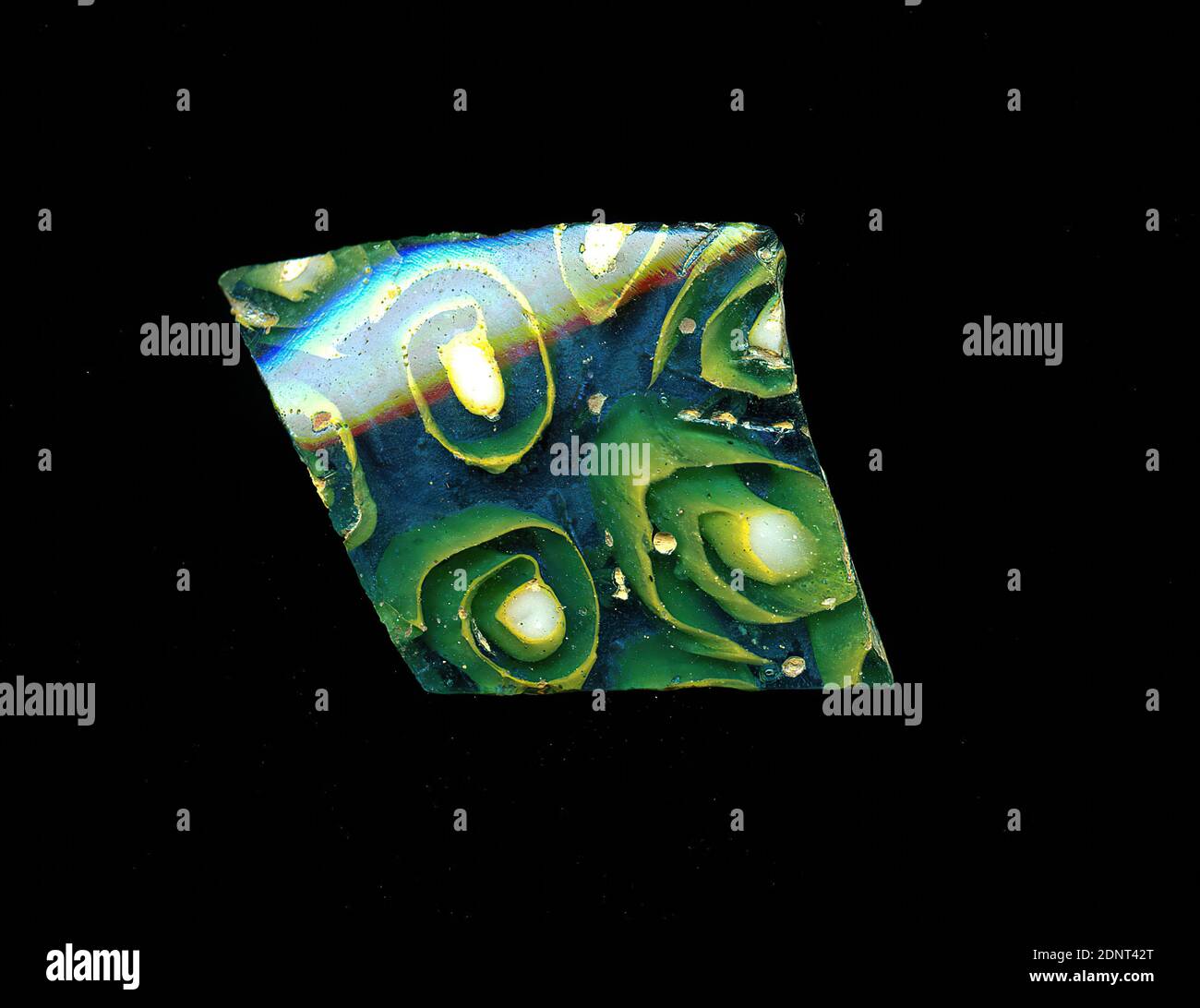 Fragment d'un vaisseau, verre, technique millefiori, Total: Hauteur: 3.30 cm; largeur: 2.30 cm, conteneur, stockage, travail de cuisine, ornements de fleurs, période impériale précoce, UNE légère courbure du fragment de verre permet l'affectation à un vaisseau, éventuellement un bol. Sur fond bleu, certaines fleurs sont représentées dans la technique de millefiori. Ils se composent d'un point blanc autour duquel une ligne jaune s'enroule comme une spirale. Pour la production, des verres de différentes couleurs ont été formés en tubes et en tiges. Ils ont été pressés ensemble et chauffés, ce qui a donné une longue tige. Banque D'Images