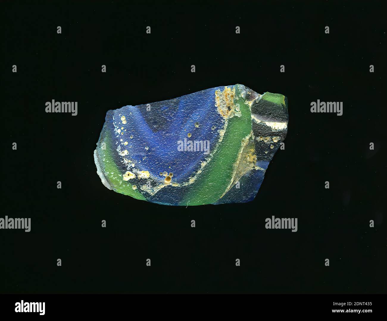 Fragment d'un vaisseau, verre, pressé, coupé, Total: Hauteur: 1.60 cm; largeur: 2.10 cm, conteneur, stockage, travail de cuisine, début de la période impériale, UNE légère courbure du fragment de verre permet l'affectation à un vaisseau. Le verre est bleu, vert et rouge foncé. Des lignes blanches couvrent la surface. Pour la production, différentes lunettes de couleur ont été fusionnées et mises en forme. En raison du processus de fabrication élaboré et de sa fragilité, le verre a été considéré comme l'un des articles de luxe de l'antiquité Banque D'Images