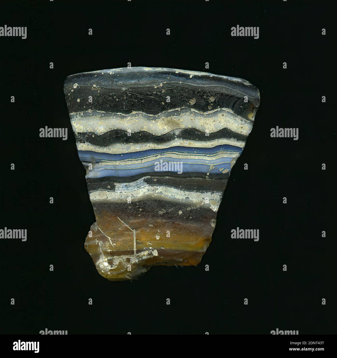 Fragment d'un vaisseau, verre, pressé, coupé, Total: Hauteur: 4.00 cm; largeur: 3.90 cm; profondeur: 0.60 cm, récipient, stockage, travail de cuisine, période impériale précoce, UNE légère courbure et le bord préservé du fragment de verre permettent l'affectation à un vaisseau, éventuellement un bol. Le verre brun foncé à brun clair est parsemé de bandes horizontales blanches et bleues sur l'extérieur. À l'intérieur, il y a trois bandes blanches. Pour la production, des verres de différentes couleurs ont été formés en tubes et en tiges. Ils ont été pressés ensemble et chauffés. Banque D'Images