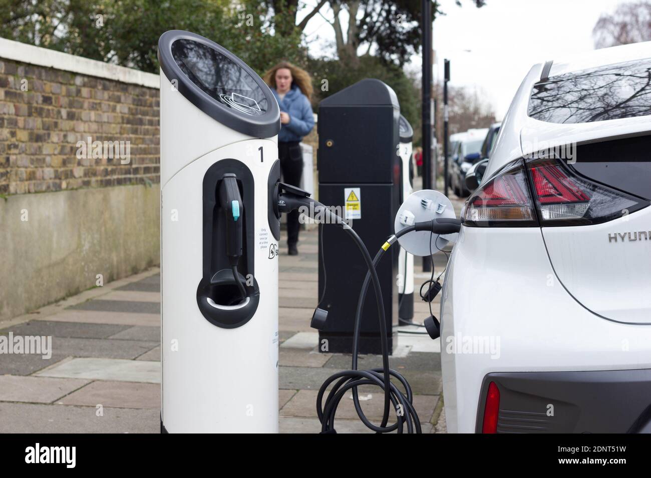 voiture électrique hyundai blanche branchée au point de charge sur le Le bord de la route à Londres Banque D'Images