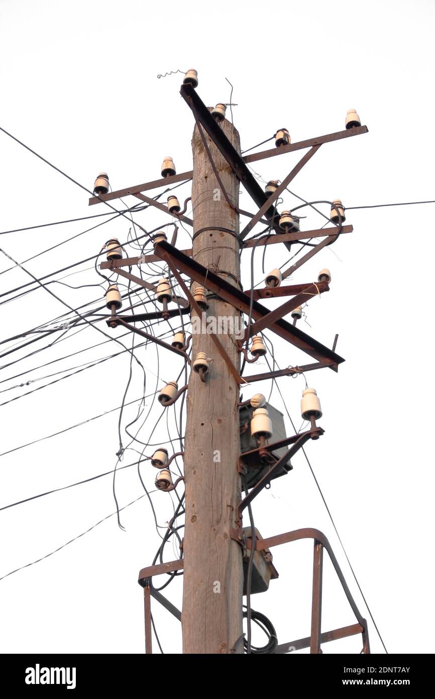 Ancien poteau téléphonique avec de nombreux isolants et fils isolés arrière-plan blanc Banque D'Images