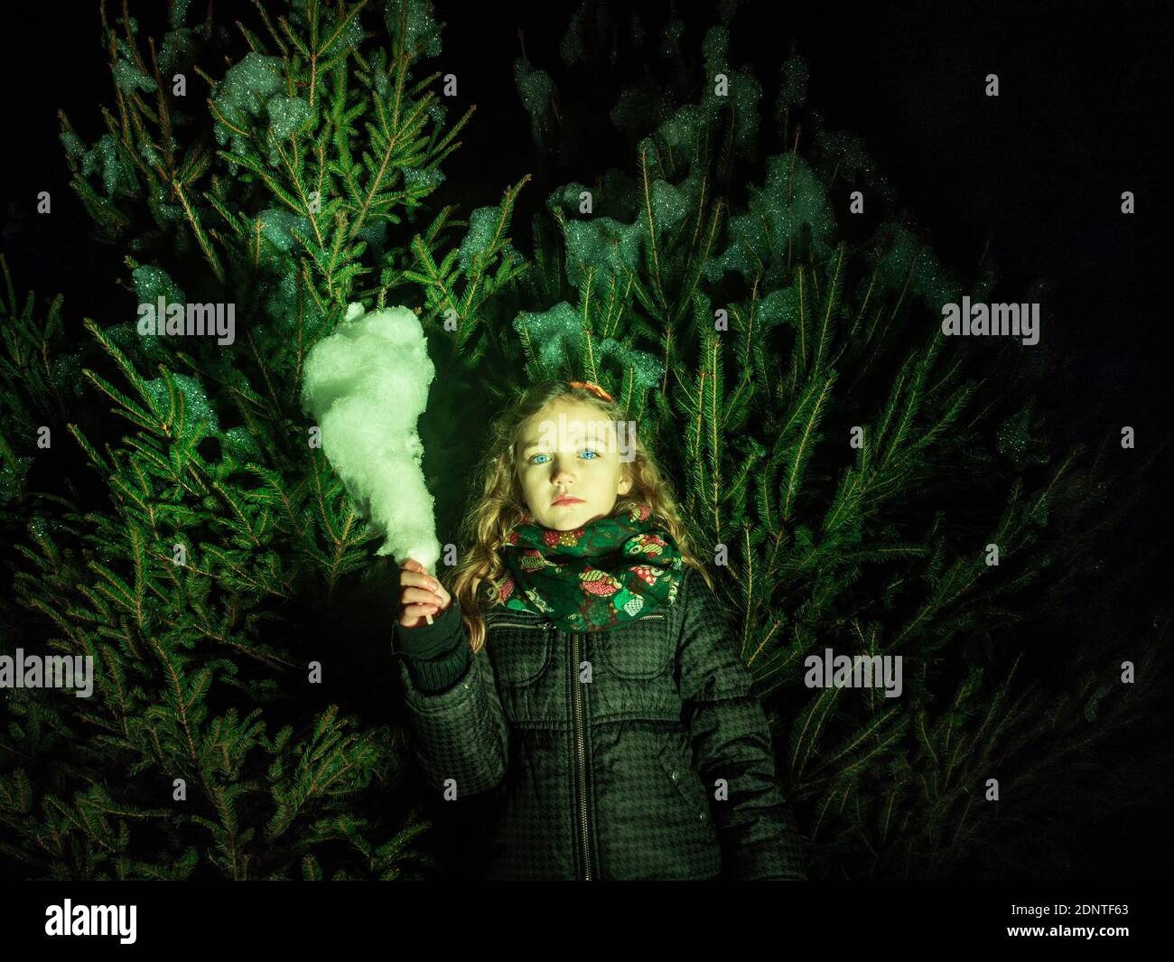Portrait d'une fille avec candyfloss debout devant un arbre de Noël, Italie Banque D'Images