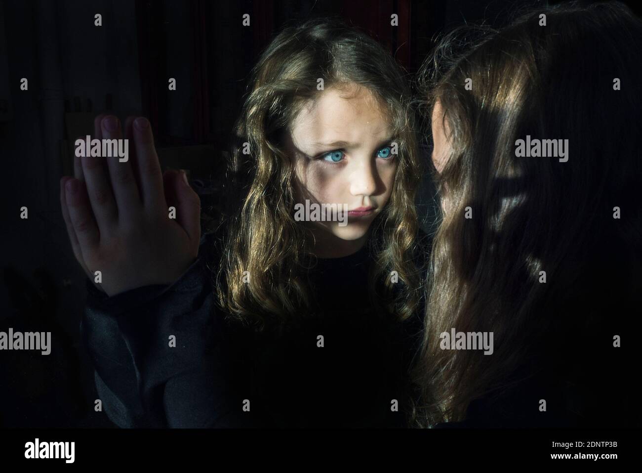 Portrait d'une fille regardant sa réflexion dans un miroir Banque D'Images