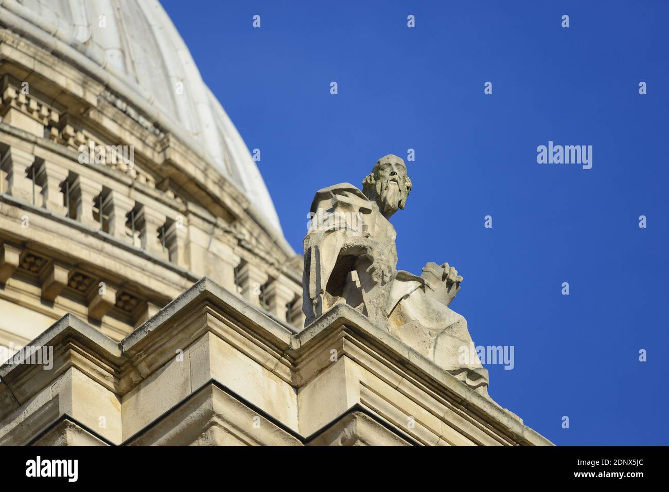 Londres, Angleterre, Royaume-Uni. Cathédrale Saint-Paul. Statue de Saint-Simon le Zealot / Simon Zelote assis, avec une scie sur la façade sud Banque D'Images