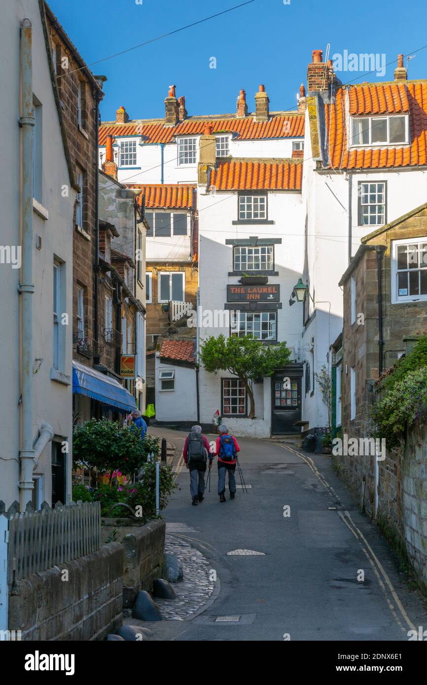 Vue sur les randonneurs et les maisons blanches sur New Road dans Robin Hood Bay, North Yorkshire, Angleterre, Royaume-Uni, Europe Banque D'Images