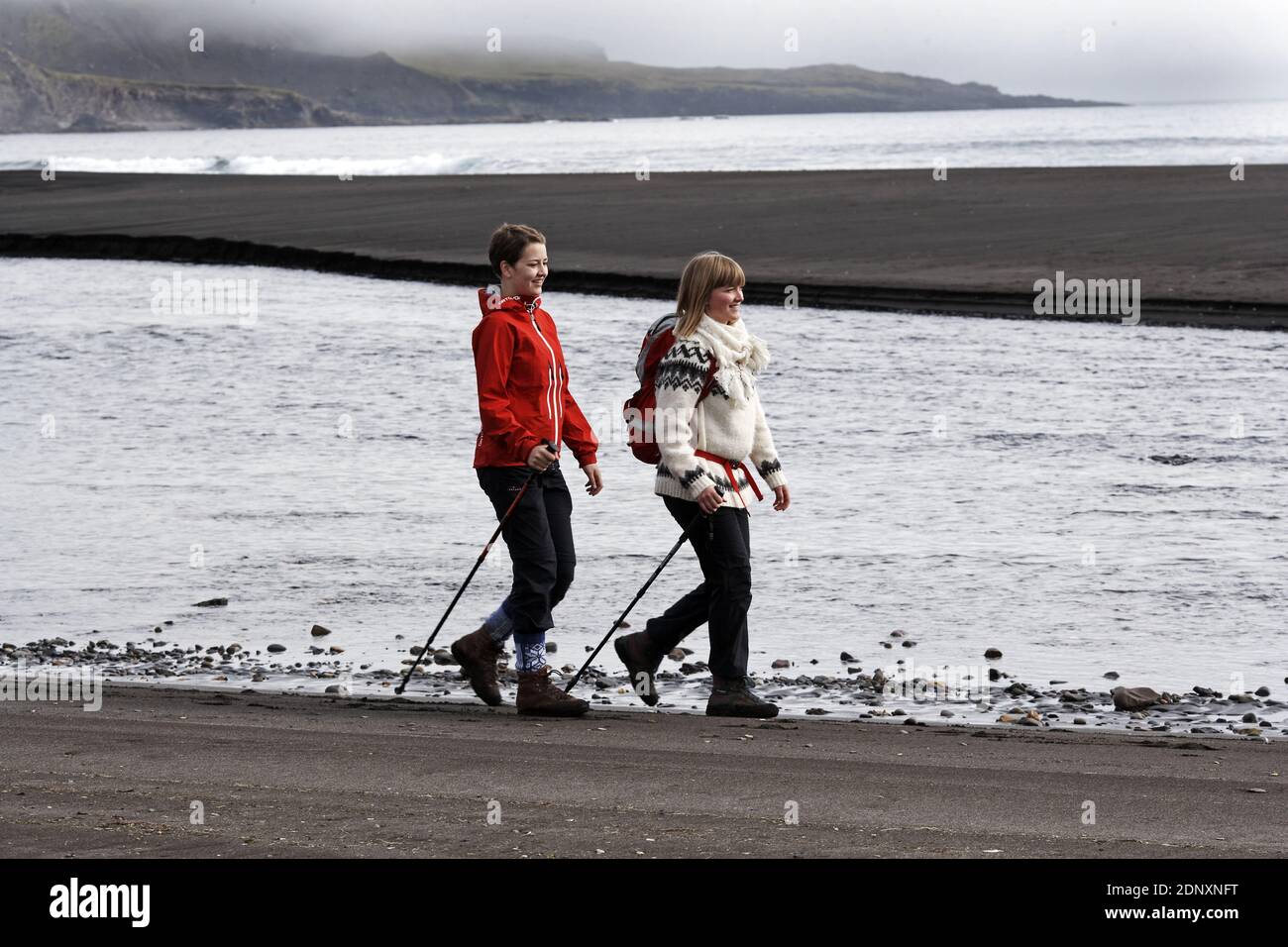 Deux femmes qui font de la randonnée sur la plage près de Breidavik, en Islande Banque D'Images