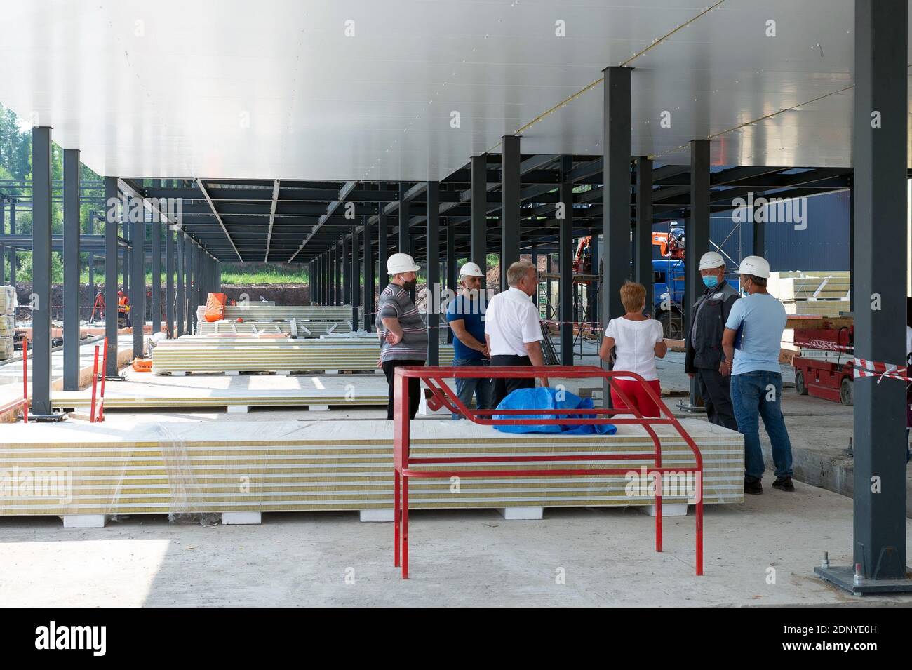 La commission de travail délibère sur le site de construction entre le colonnes métalliques du centre d'aide médicale et de secours construction sur un soleil Banque D'Images
