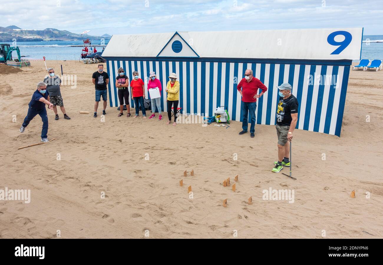 Las Palmas, Grande Canarie, Îles Canaries, Espagne. 18 décembre 2020. Vieux touristes finlandais jouant mölkky (un jeu de quilles populaire en Finlande) sur la plage de la ville de Las Palmas sur Gran Canaria. Selon l’Organisation internationale du tourisme de l’ONU, les arrivées de touristes dans le monde entier ont chuté de 72% au cours des 10 premiers mois de 2020, avec des restrictions sur les voyages, une faible confiance des consommateurs et une lutte mondiale pour contenir le virus COVID-19, qui ont tous contribué à la pire année de l’histoire du tourisme. Crédit : Alan Dawson/Alay Live News Banque D'Images