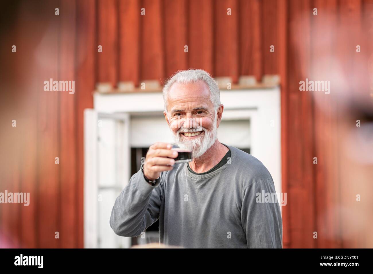 Homme souriant ayant du vin rouge Banque D'Images