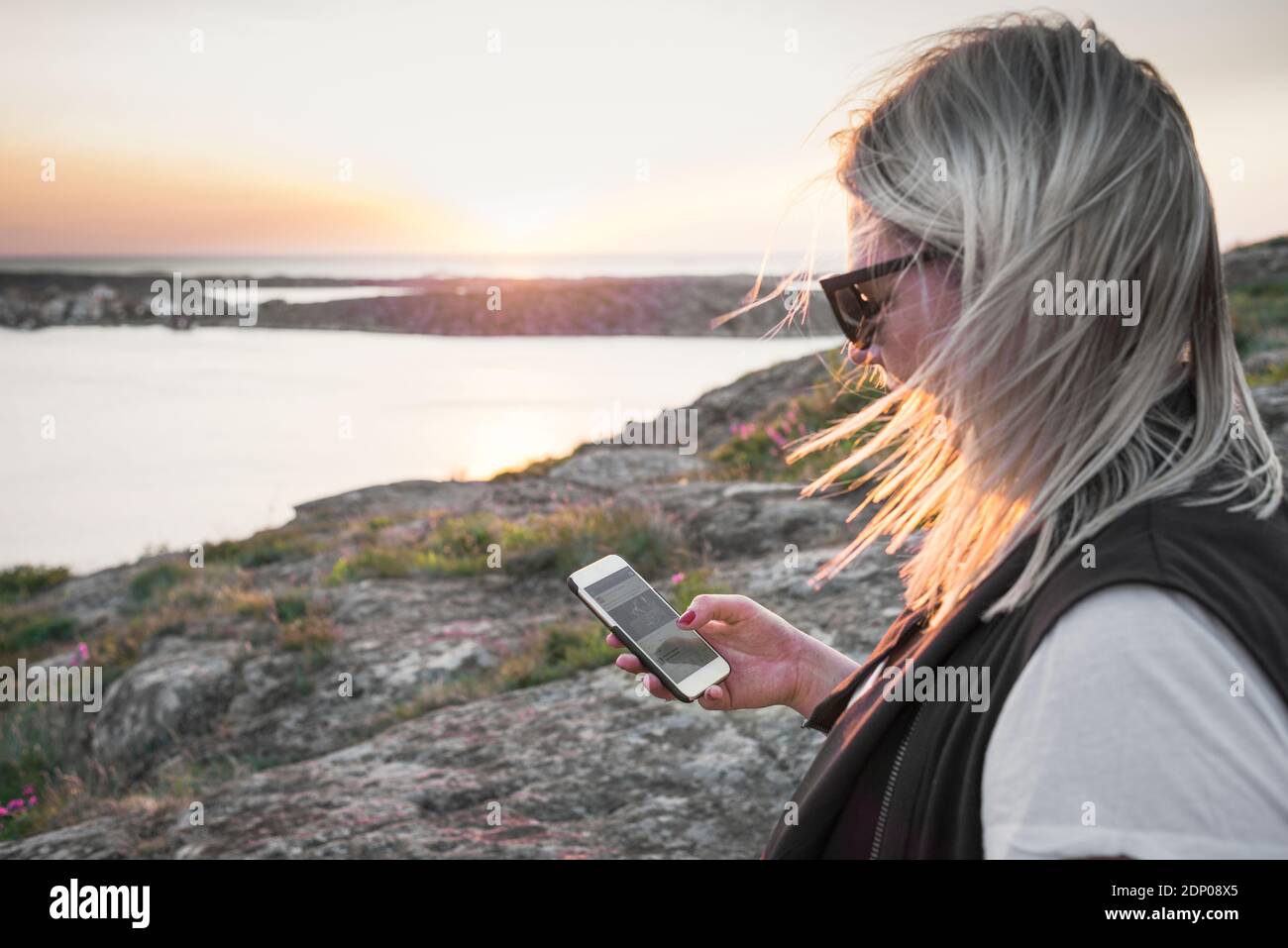 Femme utilisant un téléphone cellulaire en mer Banque D'Images