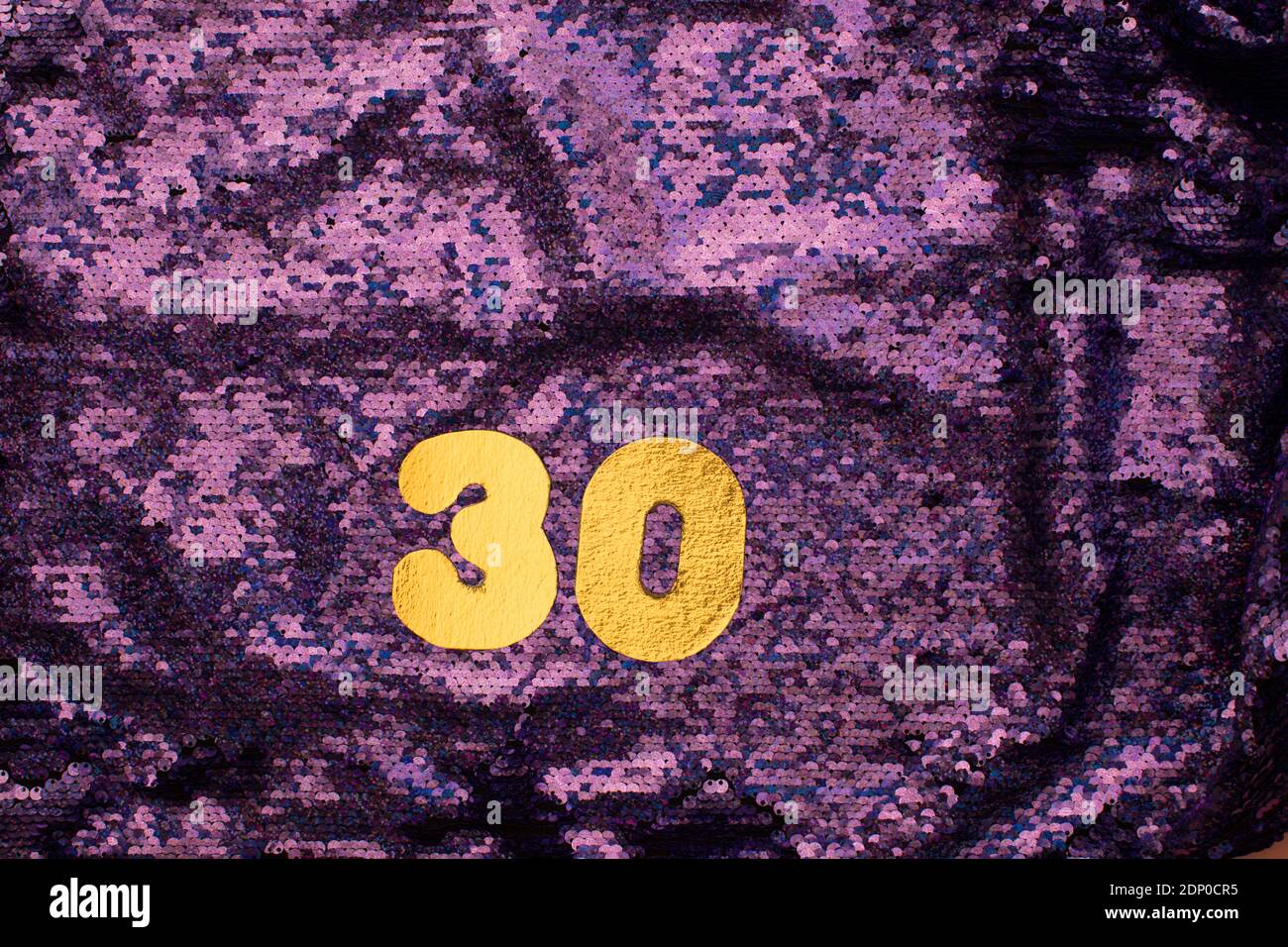 Numéros dorés 30 sur fond violet pailleté de paillettes Banque D'Images