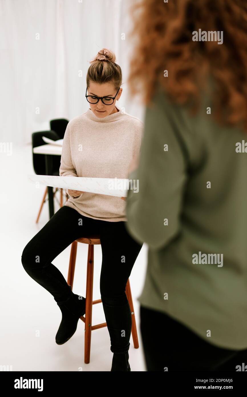 Femme lisant des documents au travail Banque D'Images