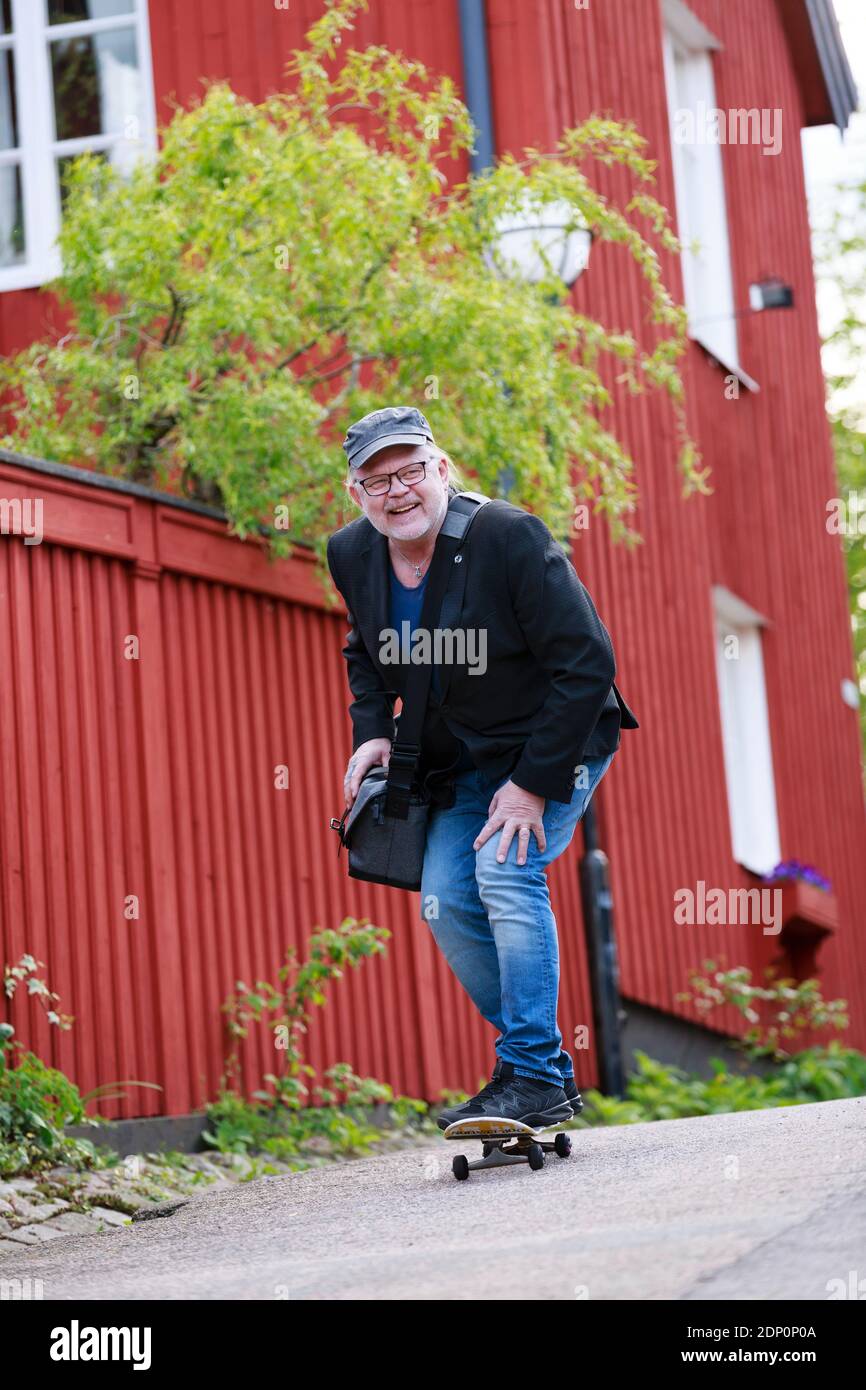 Homme souriant skate sur le trottoir Banque D'Images