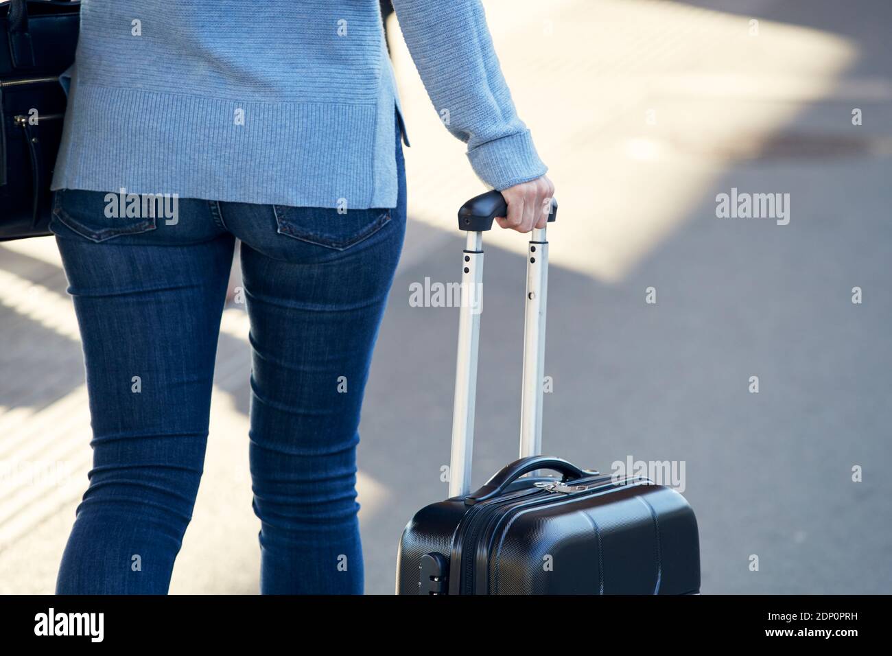 Femme tenant une poignée de valise Banque D'Images