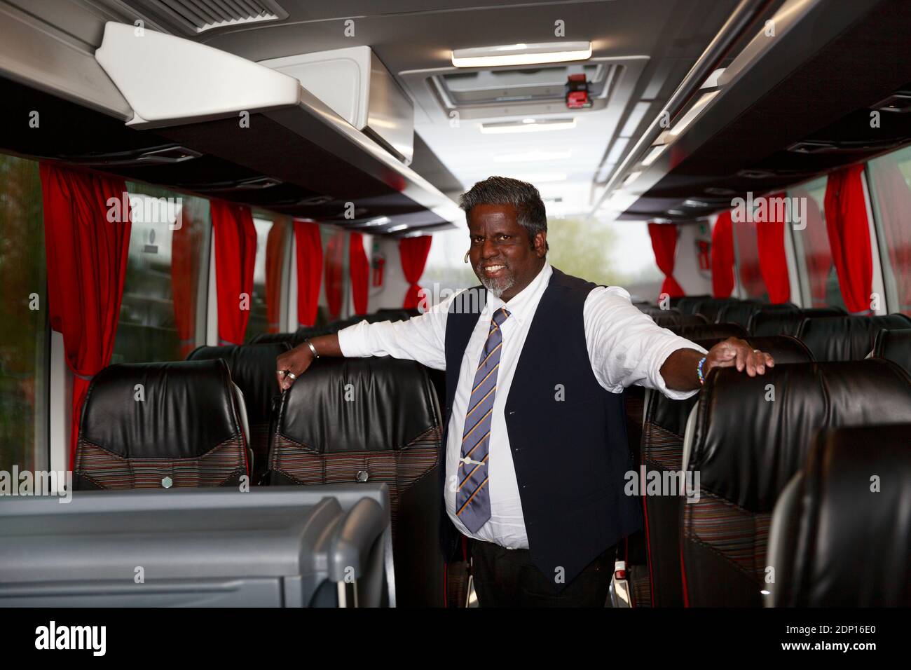 Chauffeur souriant debout dans le bus Banque D'Images