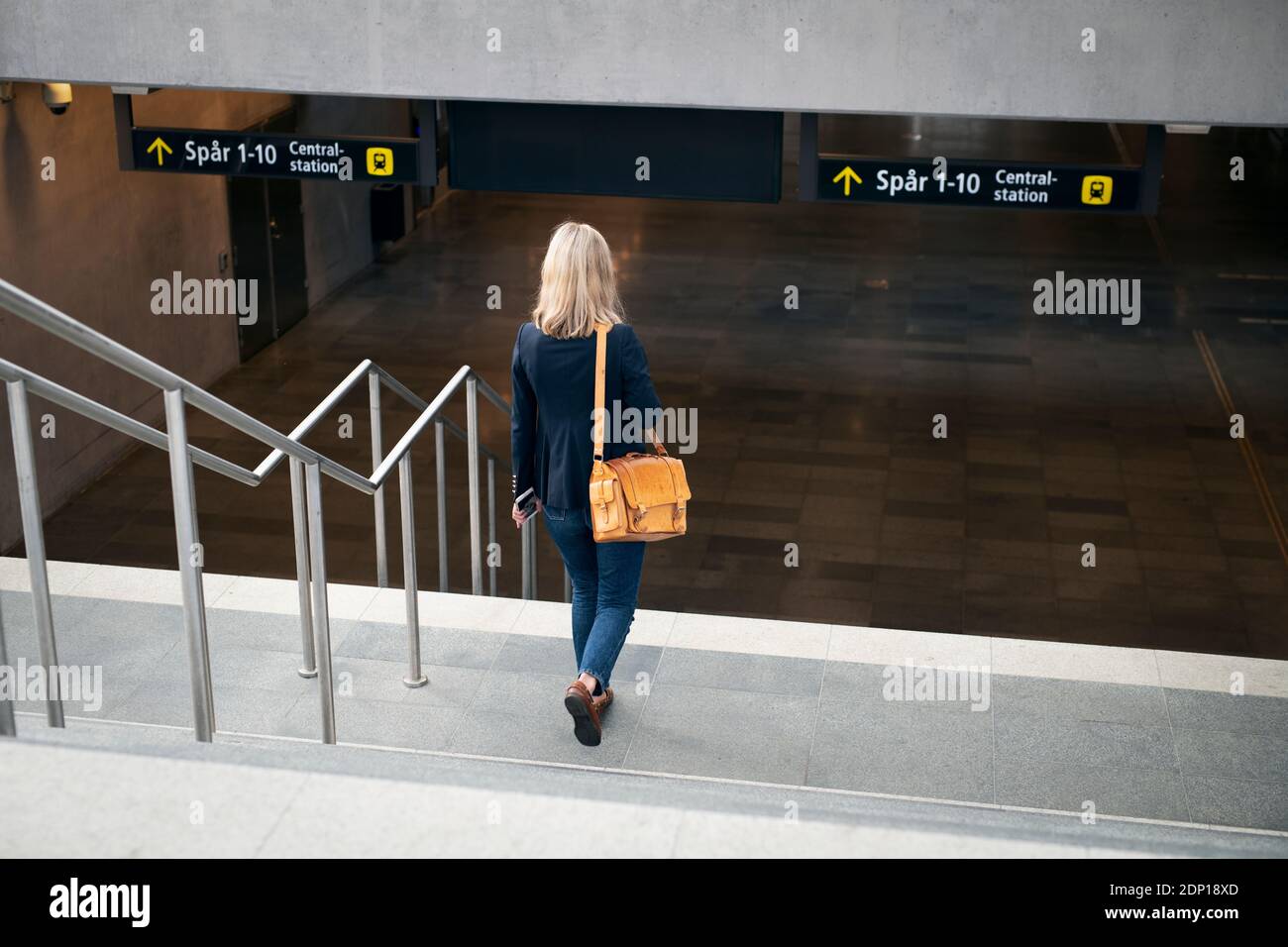 Une femme qui se promette en bas pour aller à la gare Banque D'Images