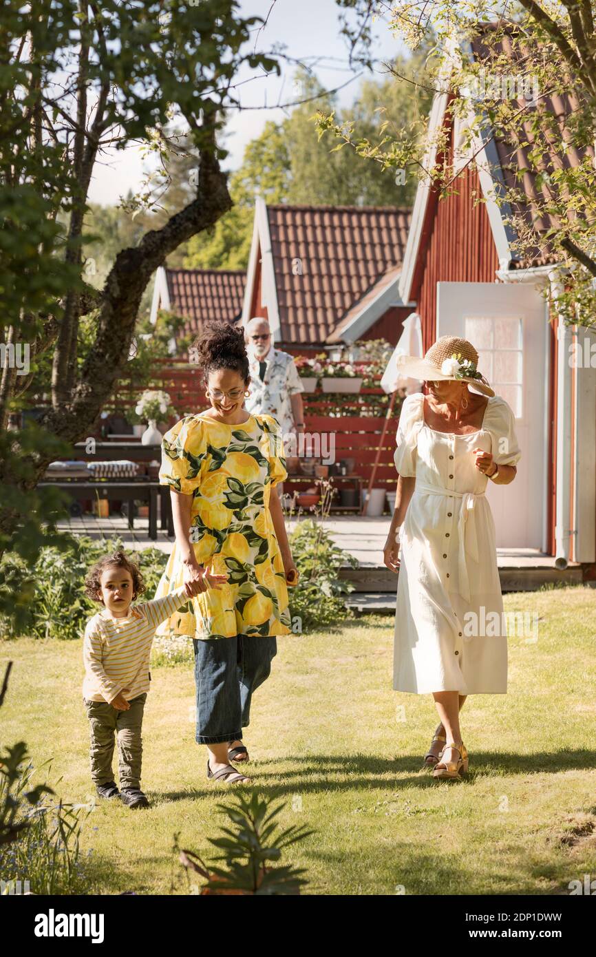 Un tout-petit garçon marchant avec sa mère et sa grand-mère Banque D'Images