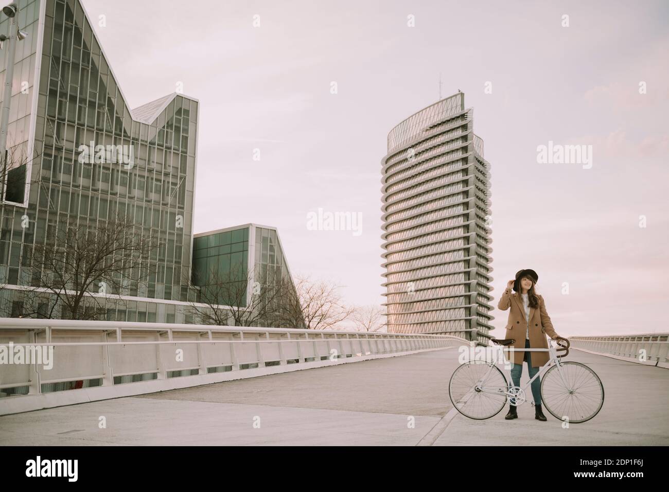Jeune femme hippie avec un vélo sur le pont dans la ville Banque D'Images