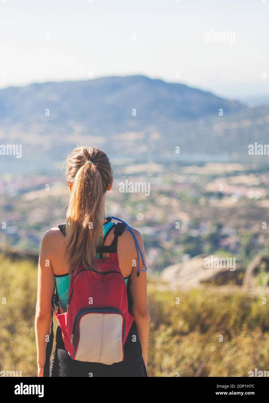 Sport fille de derrière regarde à l'horizon de la vallée le jour d'été ensoleillé Banque D'Images