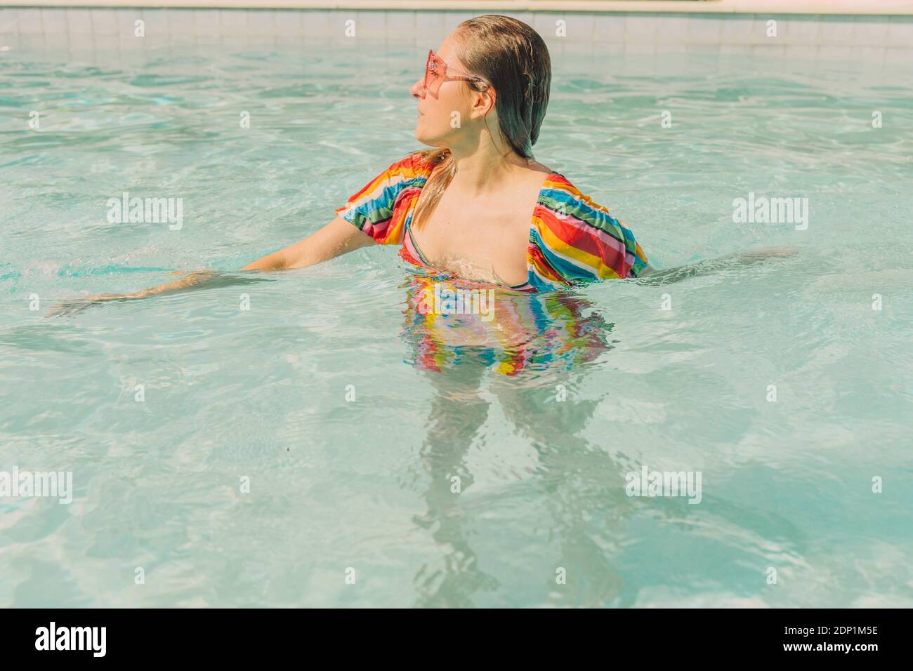 Femme habillée se détendant dans la piscine Banque D'Images