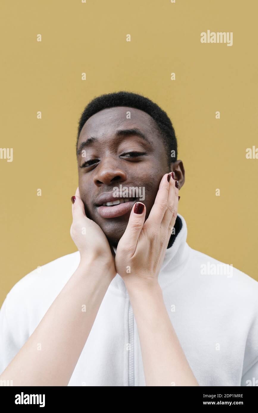 Portrait de l'homme souriant touché par les mains de la femme Banque D'Images