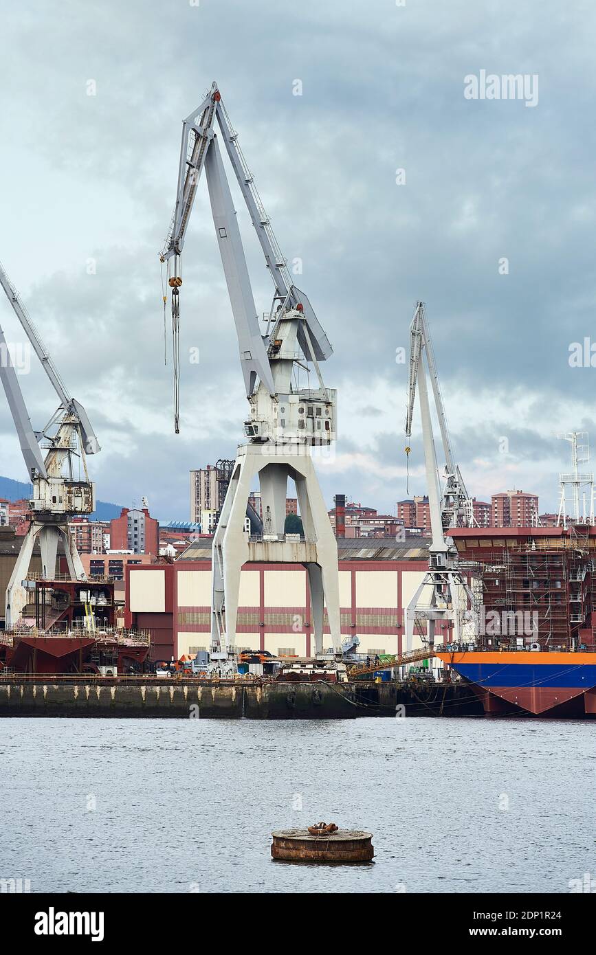 Grues dans le chantier naval sur ciel nuageux Banque D'Images