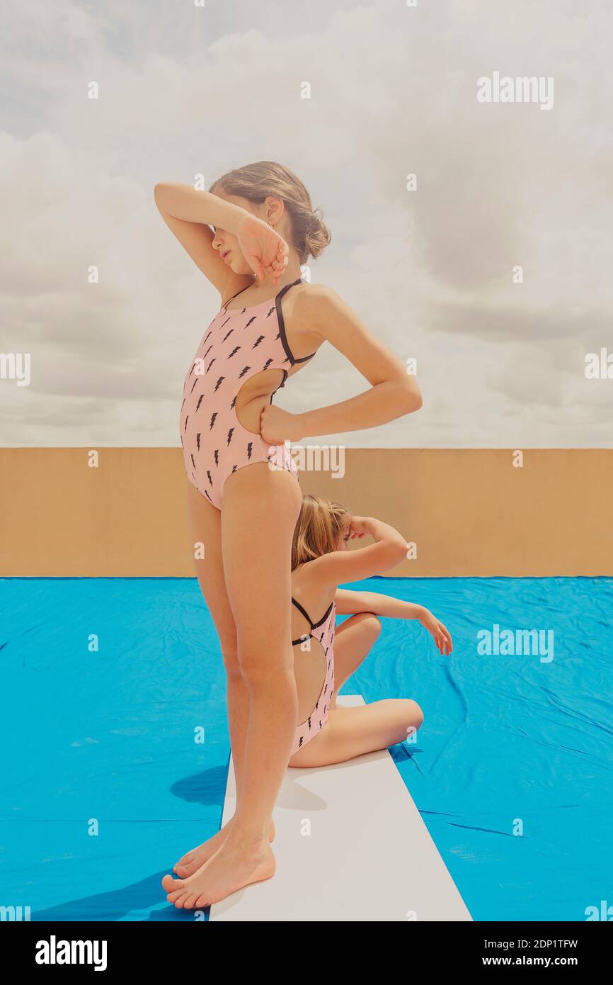 Deux filles jouant à la piscine sur la terrasse du toit Banque D'Images