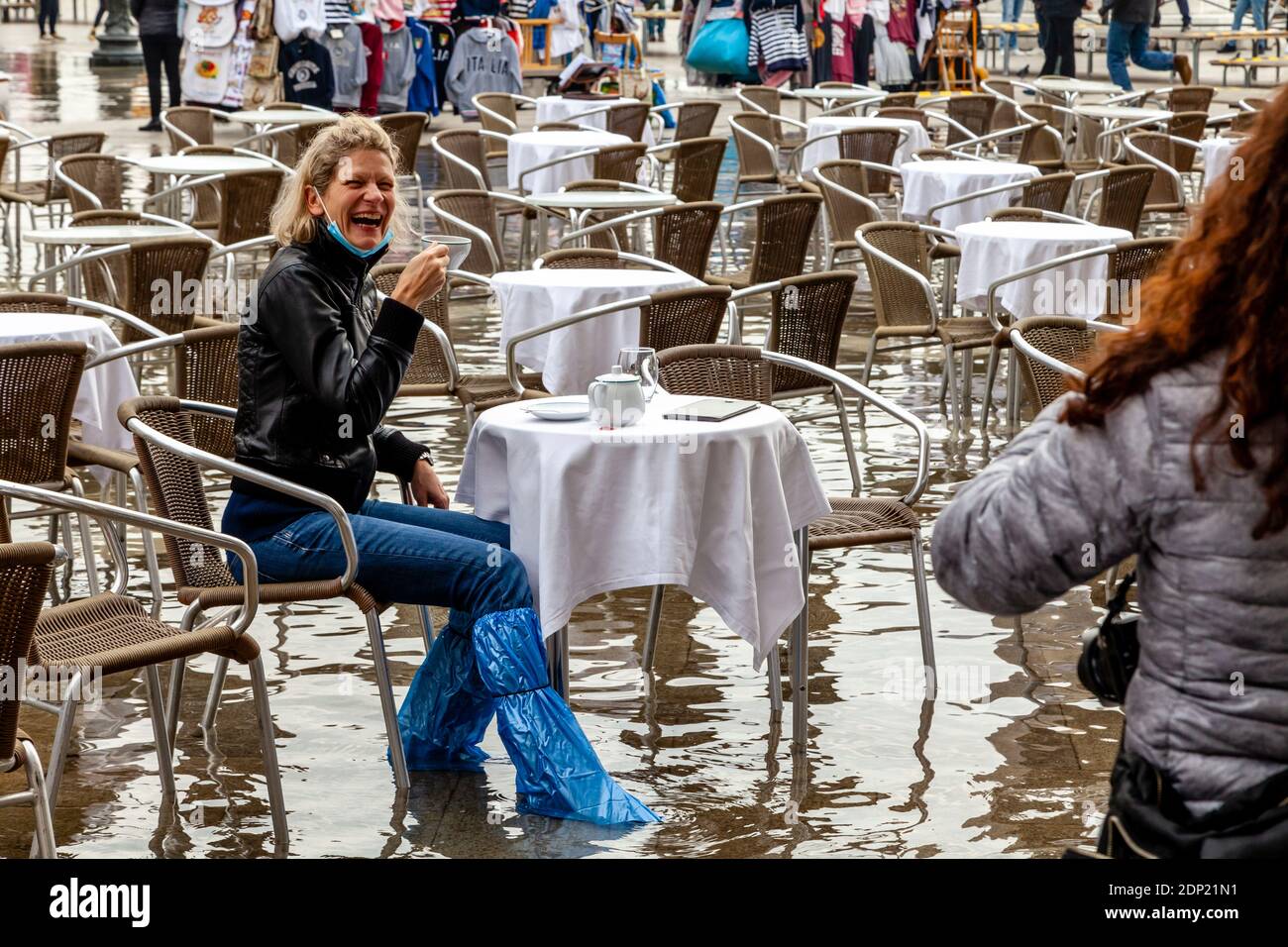 Une femme buvant du thé dans UN café de la place Saint-Marc pendant l'Acqua Alta (High Tide), Venise, Italie. Banque D'Images