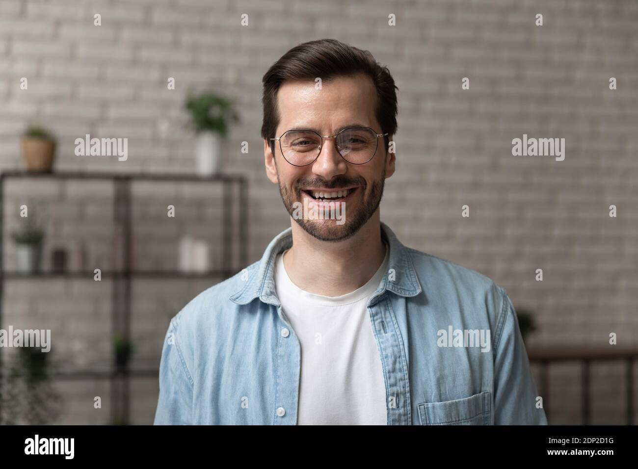 Jeune homme heureux posant pour la photo de profil de portrait de tête à l'intérieur Banque D'Images