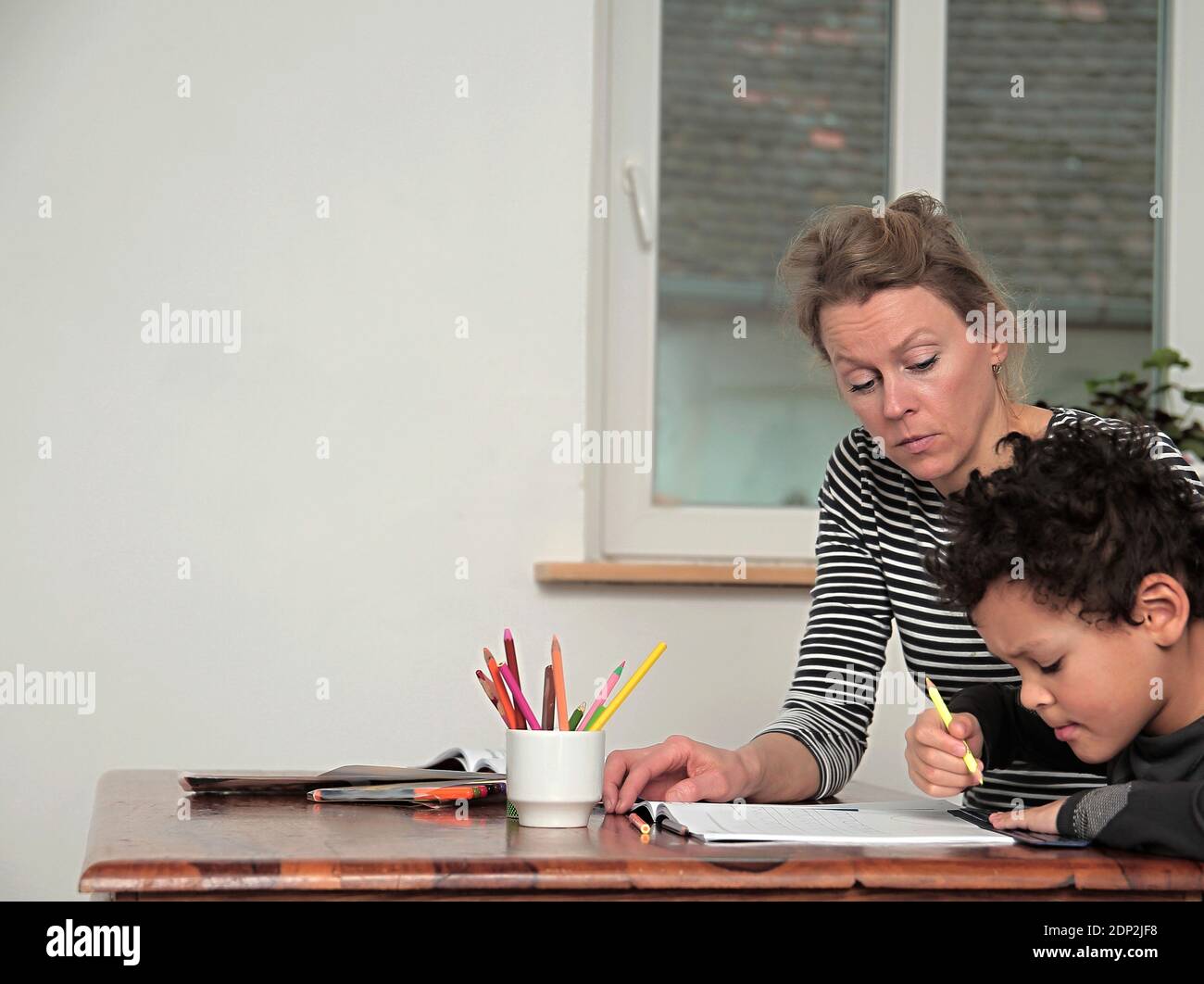 garçon apprenant à la maison avec la mère et l'enfant assis à une photo de table Banque D'Images