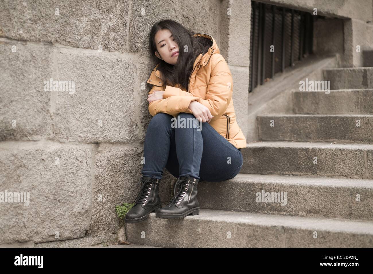 Jeune femme chinoise attractive triste et déprimée en veste d'hiver ...