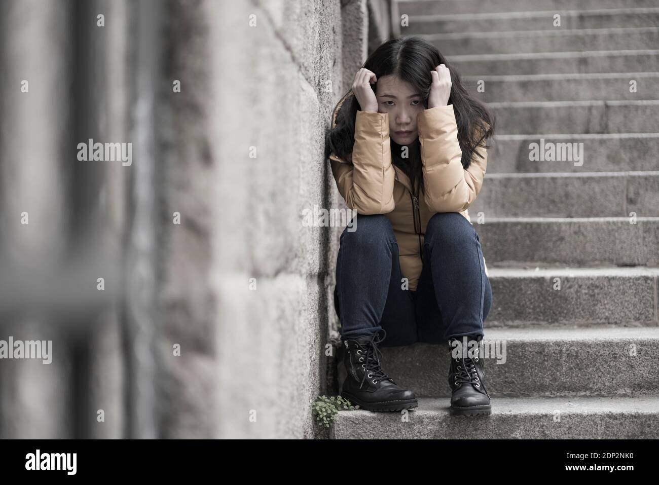 Jeune femme chinoise attractive triste et déprimée en veste d'hiver ...