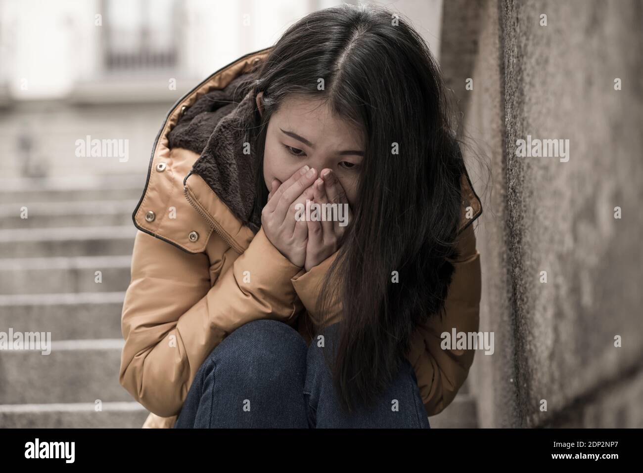 Jeune femme chinoise attractive triste et déprimée en veste d'hiver ...