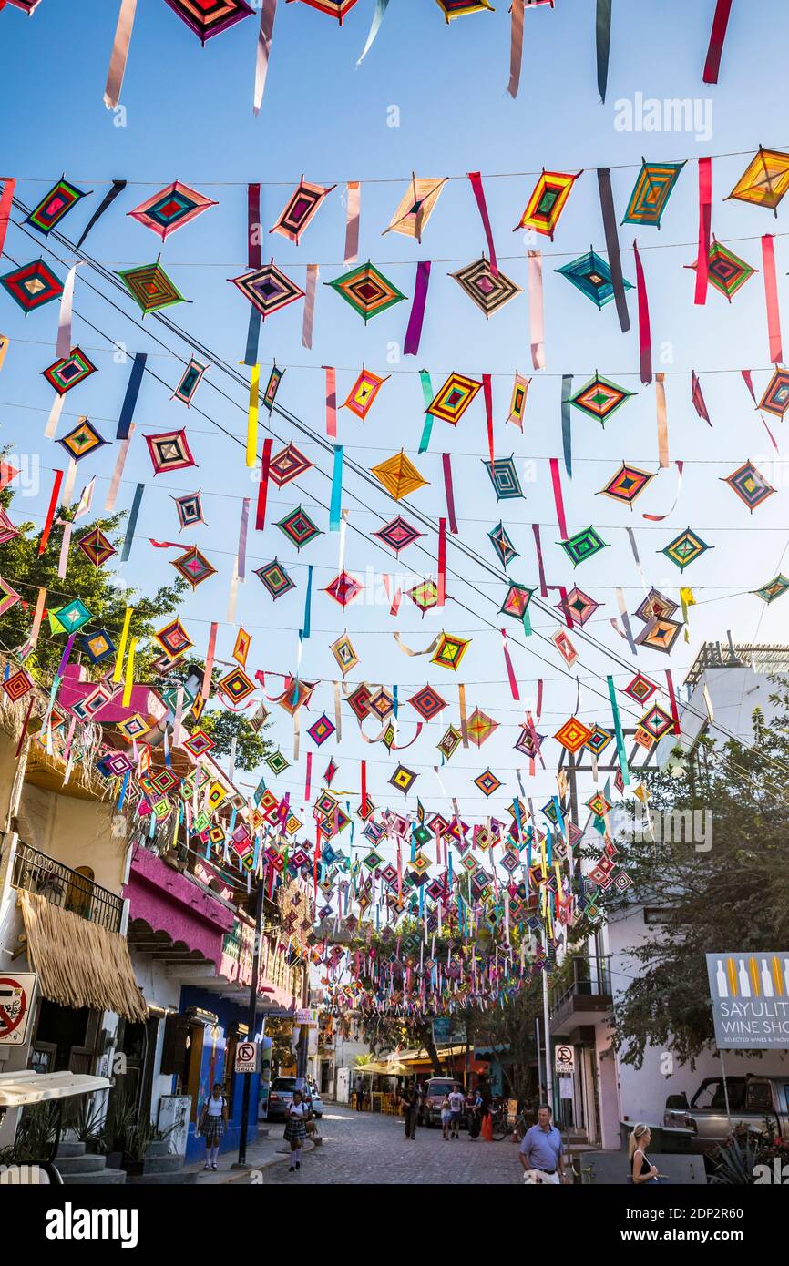 Ojos de Dios ou « l'œil de Dieu », un symbole local et l'artisanat de la culture indigène Huichol pendent des fils au-dessus des rues de Sayulita, Nayarit, Mexique Banque D'Images