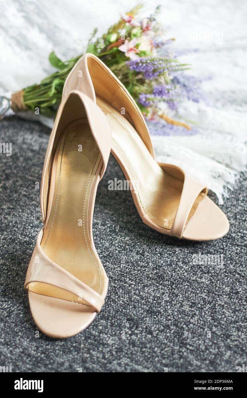 chaussures de mariage sur le tapis à côté du bouquet de la mariée et habillez-vous Banque D'Images