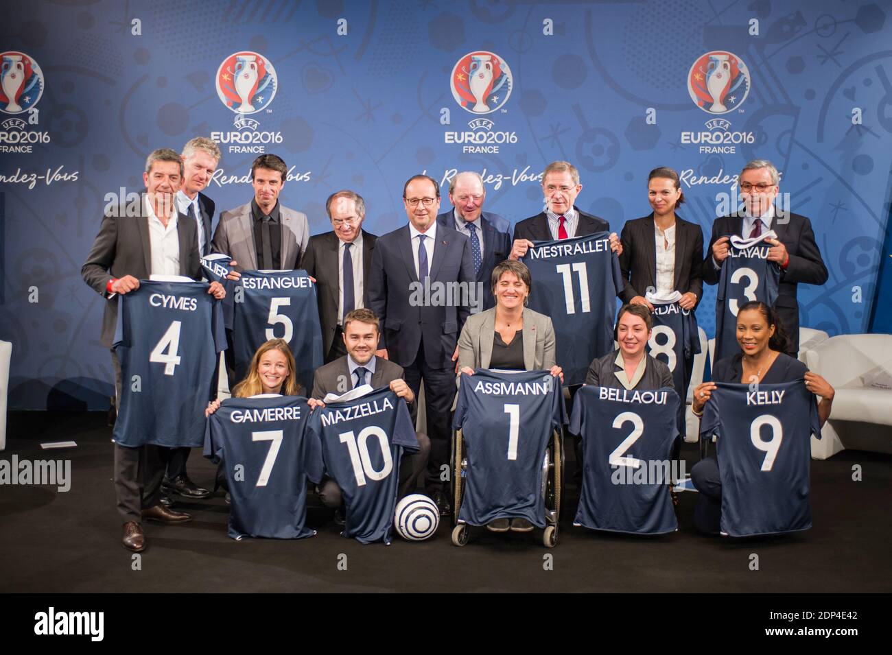 Le président français François Hollande (C) flanqué par le président de la Fédération française de football (FFF) Noël le Graet (centre L) et le président de l'Euro 2016 Jacques Lambert (centre R) pose avec les membres des "11 Tricolores" (première rangée, G-D) le directeur général du Red Star Pauline Gamerre, le président de BlaBlaCar, Frédéric Mazzella, président du Comité paralympique Emmanuelle Assmann Président du mouvement associatif Nadia Bellaoui, journaliste Christine Kelly, (2e rangée, G-D) Docteur et animateur de télévision Michel Cymes, futur président du Parc de la Villette Didier Fusillier, champion olympique Tony Estanguet, PDG d'Engie Gerard Mestrallet, Banque D'Images
