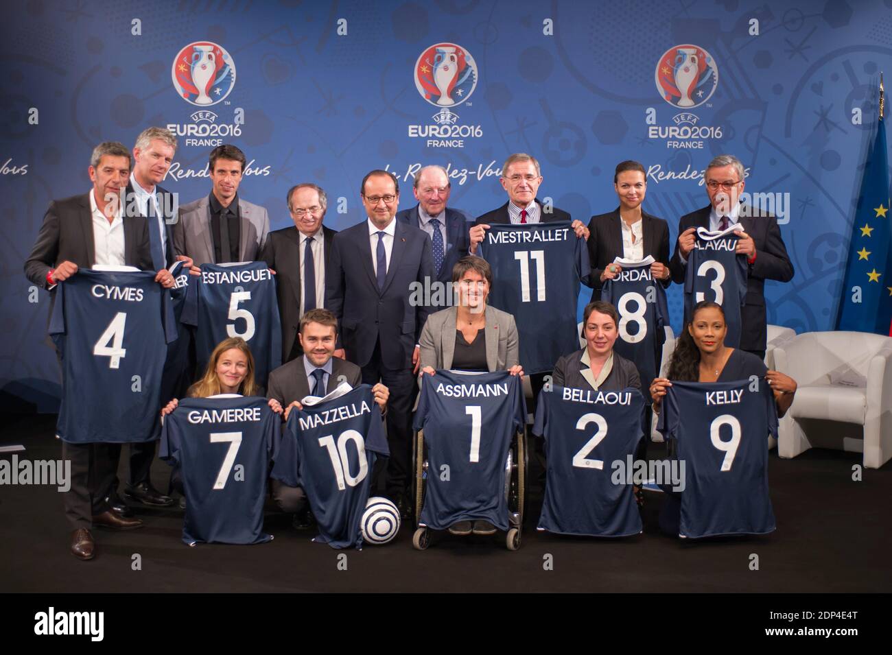 Le président français François Hollande (C) flanqué par le président de la Fédération française de football (FFF) Noël le Graet (centre L) et le président de l'Euro 2016 Jacques Lambert (centre R) pose avec les membres des "11 Tricolores" (première rangée, G-D) le directeur général du Red Star Pauline Gamerre, le président de BlaBlaCar, Frédéric Mazzella, président du Comité paralympique Emmanuelle Assmann Président du mouvement associatif Nadia Bellaoui, journaliste Christine Kelly, (2e rangée, G-D) Docteur et animateur de télévision Michel Cymes, futur président du Parc de la Villette Didier Fusillier, champion olympique Tony Estanguet, PDG d'Engie Gerard Mestrallet, Banque D'Images