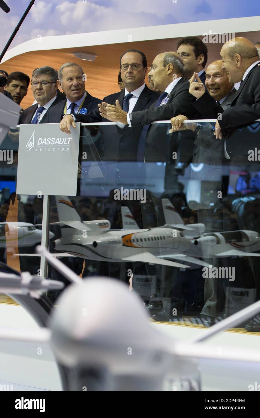 Le président français François Hollande (c) écoute les explications du président de Dassault Aviation Eric Trappier avec Charles Edelstenne(L) lors de sa visite sur le stand Dassault, lors de l'ouverture officielle du 51e salon international de l'aviation de Paris au Bourget, près de Paris, le 15 juin 2015. Photo de Romuald Meigneux/Pool/ABACAPRESS.COM Banque D'Images