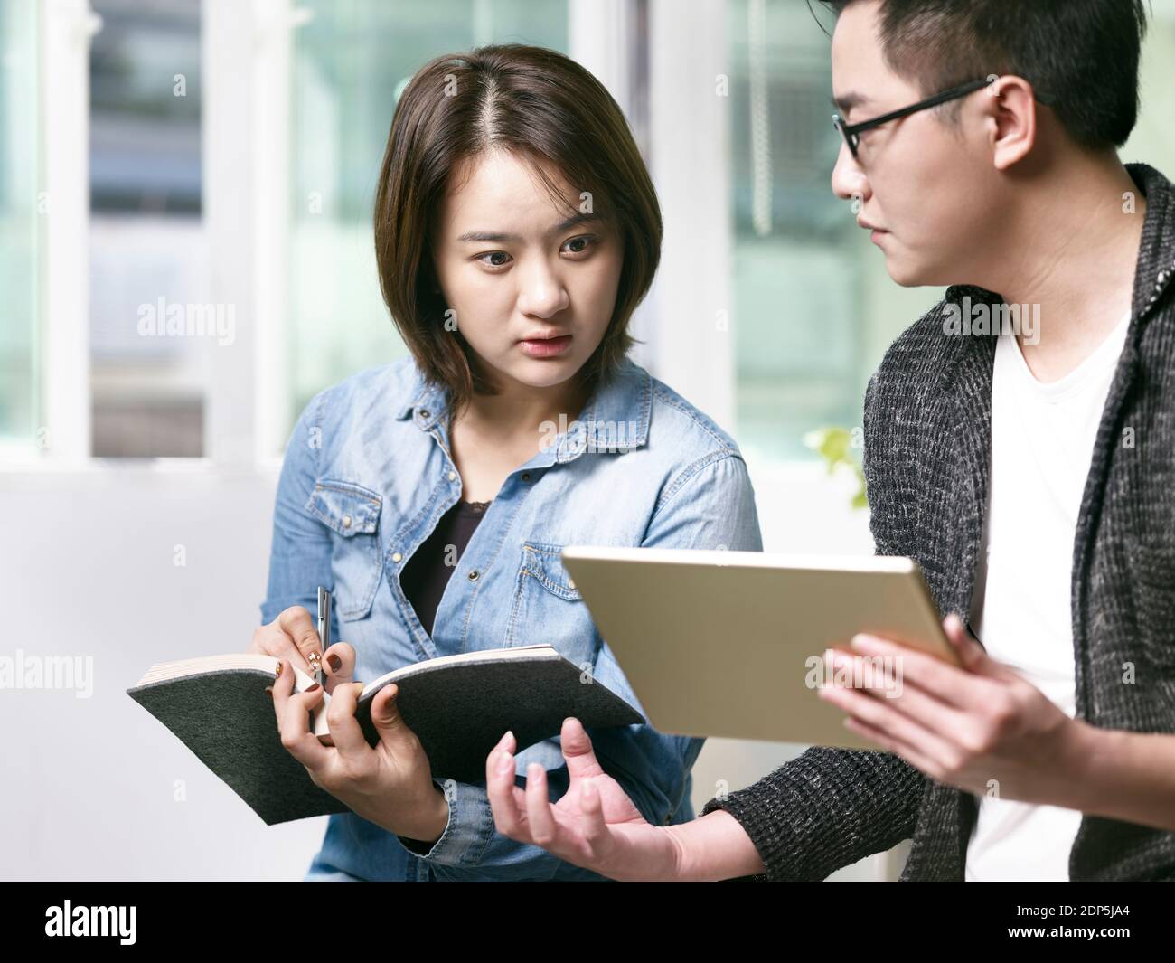 un jeune homme et une jeune femme d'asie discutent d'affaires dans le bureau en utilisant tablette numérique Banque D'Images