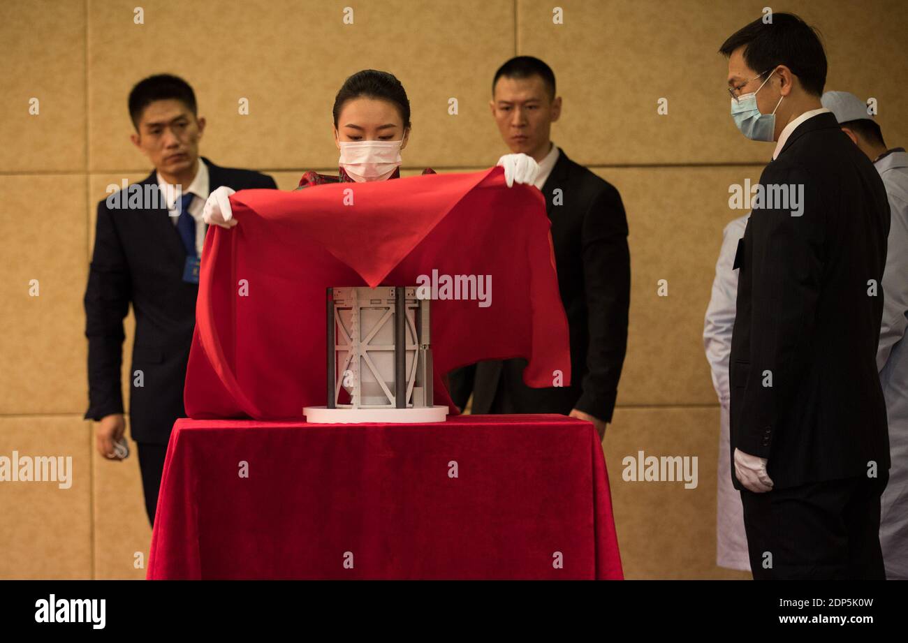 Pékin, Chine. 19 décembre 2020. Un membre du personnel couvre le conteneur d'échantillons lunaires avec un voile lors de la cérémonie de remise des échantillons lunaires Chang'e-5 à l'Administration spatiale nationale de Chine à Beijing, capitale de la Chine, le 19 décembre 2020. Des échantillons de lune prélevés par la sonde Chang'e-5 en Chine ont été transférés samedi matin aux équipes de recherche chinoises. Les scientifiques réaliseront le stockage, l'analyse et la recherche des premiers échantillons du pays prélevés sur l'objet extraterrestre. Credit: Jin Liwang/Xinhua/Alamy Live News Banque D'Images