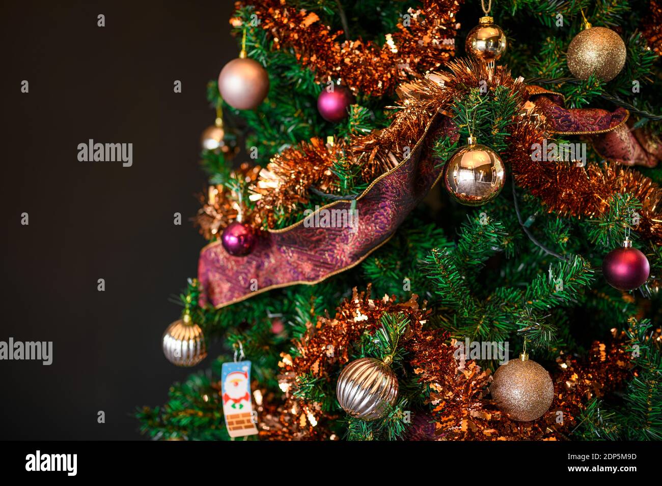 Magnifique sapin de Noël décoré sur fond sombre et flou Banque D'Images