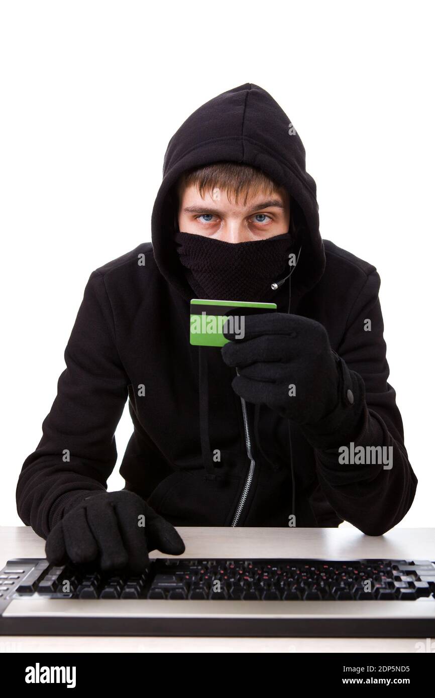 Pirate avec une carte bancaire et le clavier de l'ordinateur allumé Le fond blanc Banque D'Images