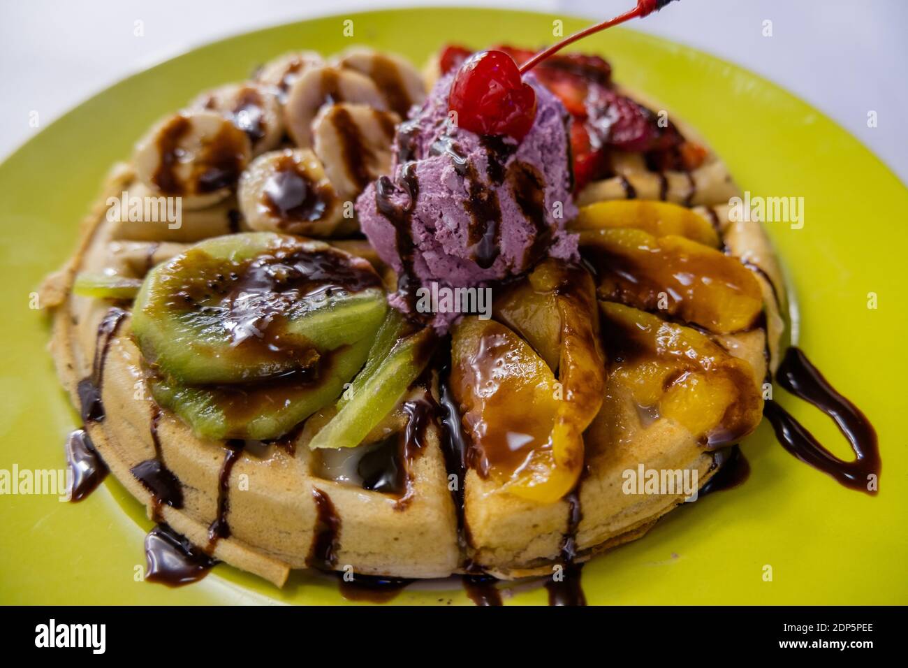 Crème glacée, fruits et sirop de chocolat sur une gaufre Banque D'Images