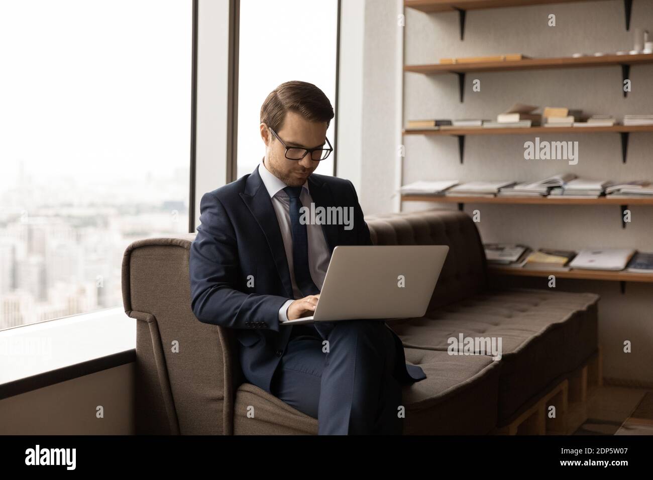 Un patron de race blanche travaille sur un ordinateur portable au bureau Banque D'Images
