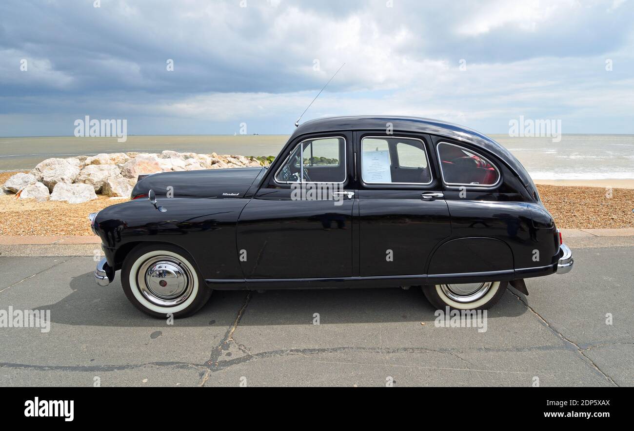 Vintage Black 1951 Standard Vanguard Motor car garée sur front de mer promenade plage et mer en arrière-plan. Banque D'Images